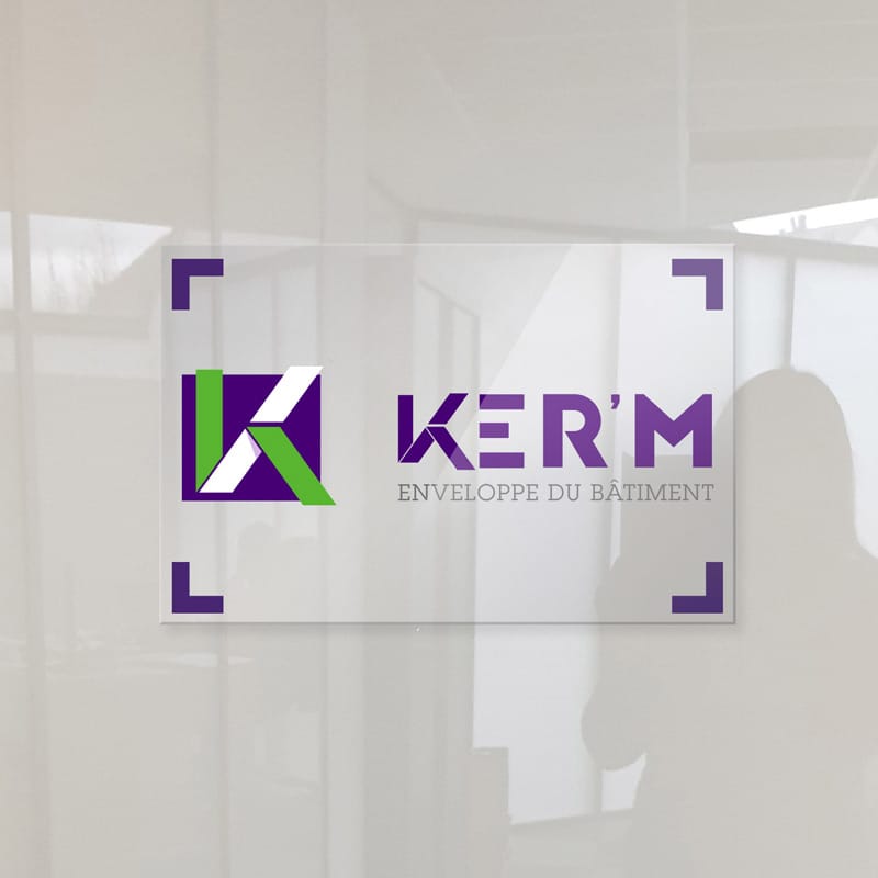 Logo KER'M violet et vert sur une vitre de bureau